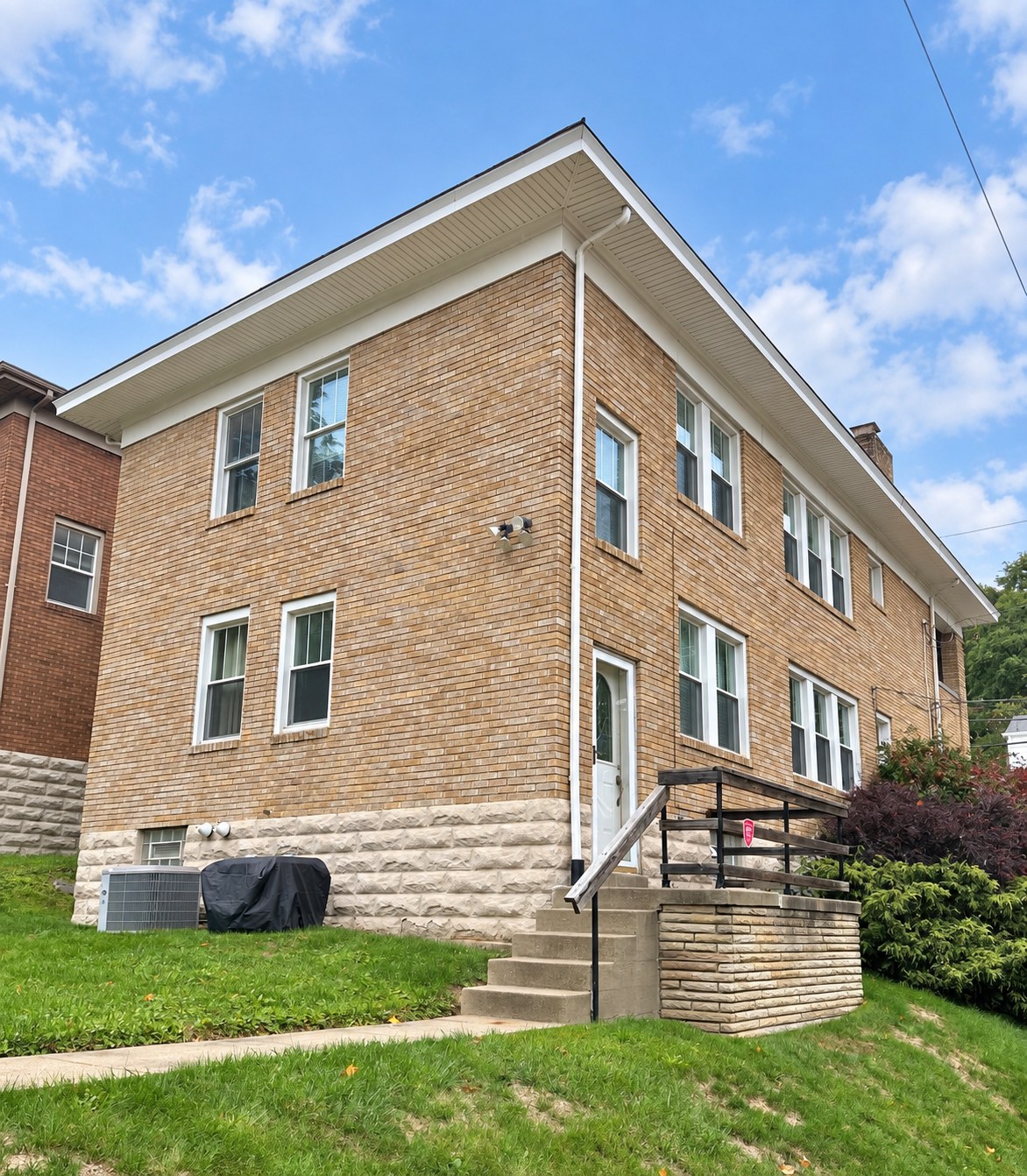 Tan brick residential building seen from the front corner