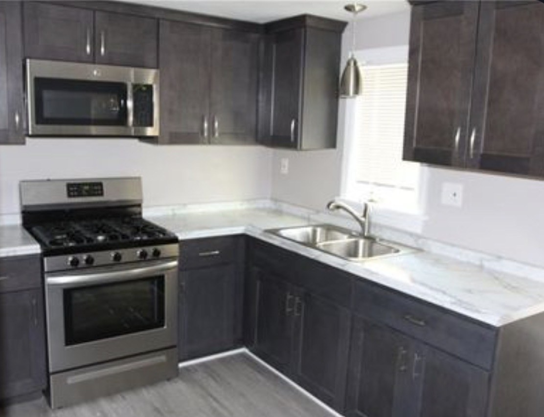 Updated kitchen with dark cabinets and stainless steel appliances